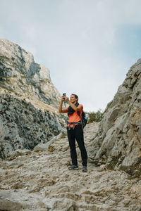 Full length of man photographing on rock