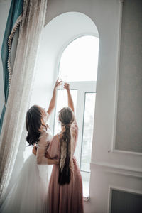 Rear view of women standing in corridor