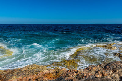 Scenic view of sea against clear blue sky