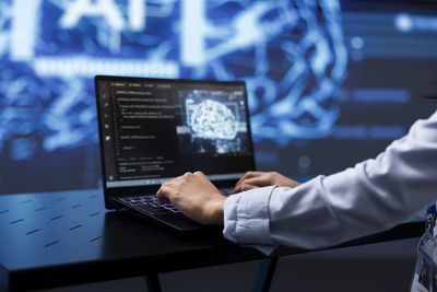 Midsection of businessman using laptop