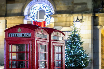 Telephone booth against illuminated building at night