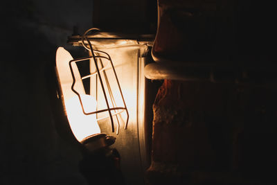 Close-up of illuminated light bulb against wall