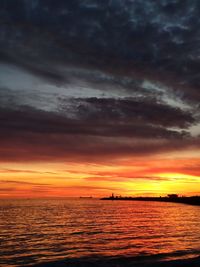 Scenic view of sea against dramatic sky during sunset