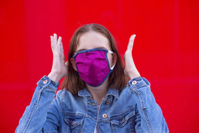 Portrait of beautiful woman against red wall