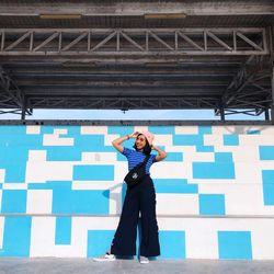 Full length of woman standing against wall