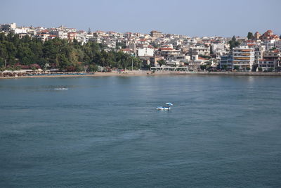 Scenic view of sea by buildings against sky