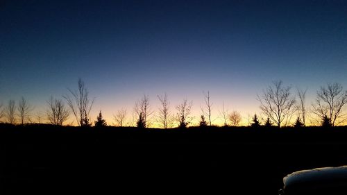 Silhouette bare trees against clear sky at sunset