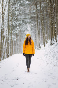 Woman walking on snow covered land