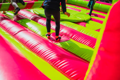 Low section of people walking on multi colored umbrella