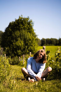 Woman sitting on grass in field