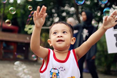 Close-up of cute boy playing with bubbles at playground