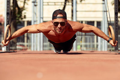 Low angle view of man with arms raised standing in city