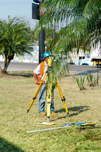 Engineer using equipment while standing on grass