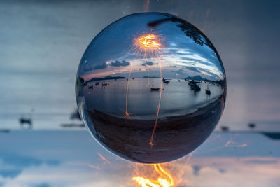 Close-up of crystal ball against sky during sunset