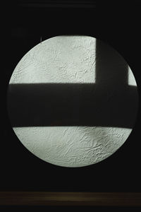 Close-up of shadow on table against black background