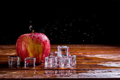 Close-up of fruits on table against black background