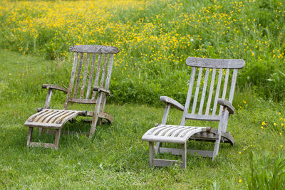 Empty chairs and table on field