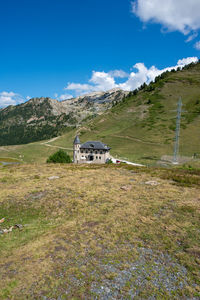 Built structure on field by mountain against sky