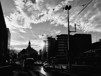 Cars on city street against sky