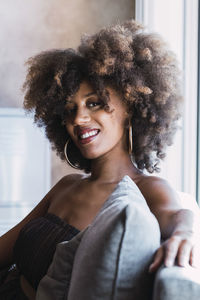 Smiling young woman with afro hairstyle at home