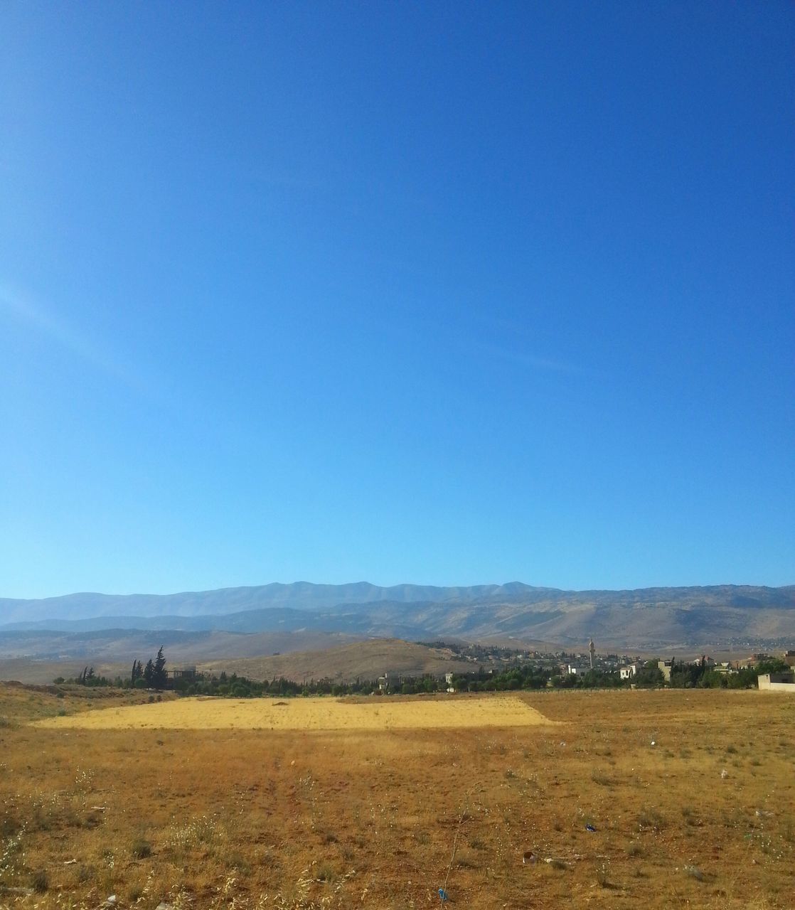 clear sky, copy space, landscape, blue, tranquil scene, tranquility, scenics, beauty in nature, mountain, nature, field, non-urban scene, horizon over land, remote, mountain range, idyllic, countryside, hill, outdoors, day