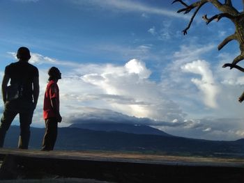 People standing on mountain against sky