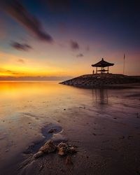 Scenic view of beach against sky during sunset
