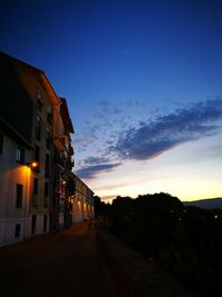 Illuminated buildings against sky at dusk