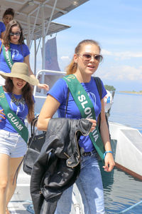 Portrait of smiling young woman by sea