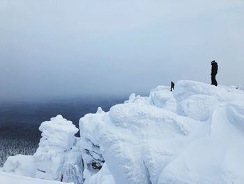 People on snow covered mountain against sky