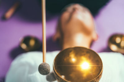 High angle view of woman with singing bowl relaxing while lying in spa