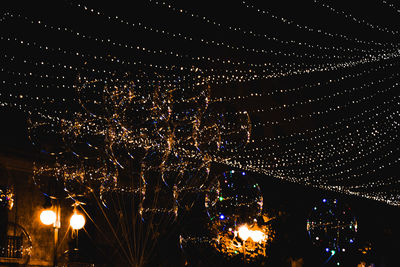 Low angle view of illuminated fireworks against sky at night