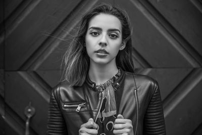 Close-up portrait of woman standing against entrance of building