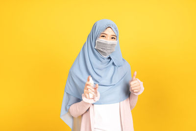 Portrait of mid adult man against yellow background