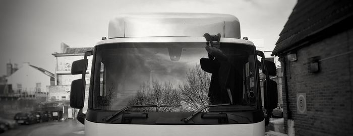 Reflection of man on car windshield on street