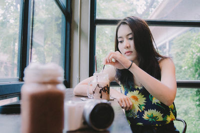 Portrait of beautiful woman sitting by window