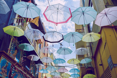 Low angle view of umbrellas hanging against sky