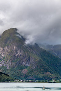 Scenic view of river and mountains against cloudy sky