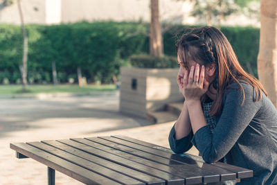 Woman sitting on bench in park