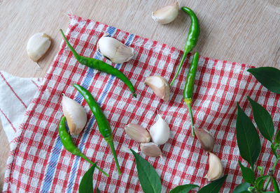 Overhead view of green chili pepper with garlic on table cloth