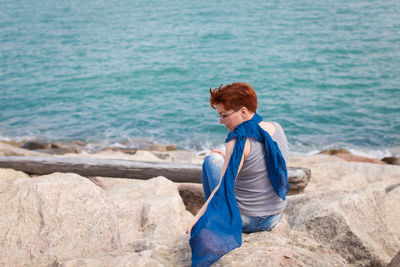 Man standing on rock by sea