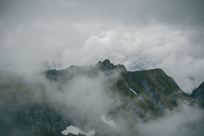 Scenic view of high mountains surrounded by clouds