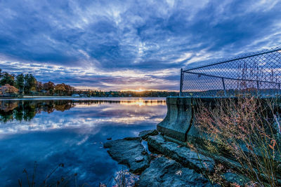 Scenic view of lake against sky at sunset
