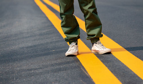 Low section of man standing on road