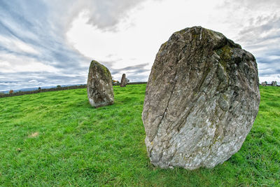 Rocks on field against sky