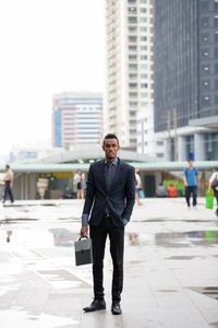 Full length portrait of businessman standing in city