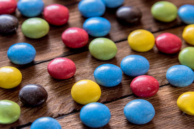 High angle view of multi colored candies on wooden table