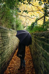 Rear view of woman standing on footpath