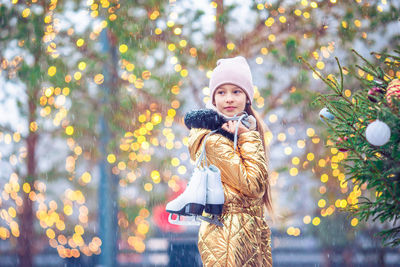 Portrait of young woman standing against trees