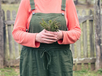 Midsection of man holding umbrella while standing on land